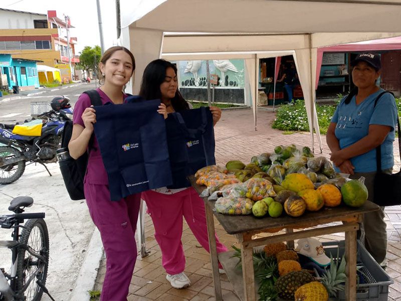 Miembros de Patitas Azules fomentando conciencia ambiental mediante la recolección de basura en las islas Galápagos