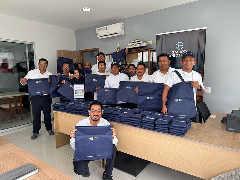 Miembros de Patitas Azules fomentando conciencia ambiental mediante la recolección de basura en las islas Galápagos